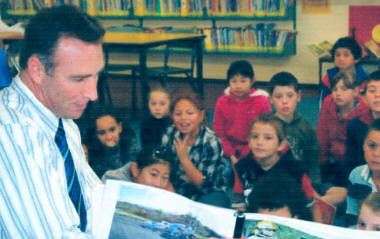 Detective Laurie Howell NZ Police reading his book to a Central Normal School class, the book is a publishers proof and more fund raising is required to allow publishing. [NZ Police]