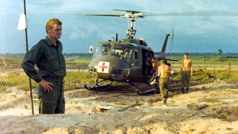 Goodman with CASEVAC chopper behind, others carrying injured Vietnamese kids to chopper [Jane]