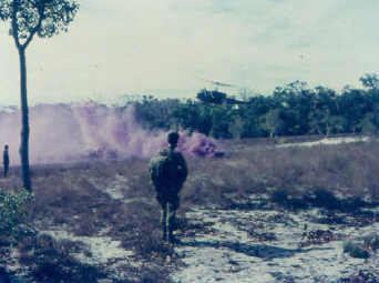 'throw smoke..!'  LP marshall on left, chopper approaching LP, soldier with pack on is waiting to return to Nui Dat, possibly for leave [Rowsell]