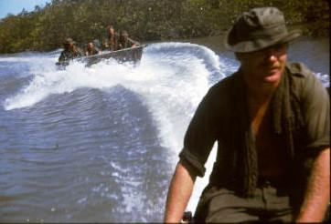 2Pl on boat patrol LONG SON Island.  Note the low front to the 'boats' and the absence of life jackets.  The 'boats' were actually designed as bridge pontoons and the outboard motors were fitted simply to hold the bridge against the river flow or tide.  They were never intended as sea boats. [Young]