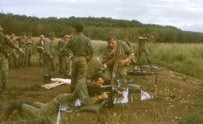 2Pl range shoot outside the wire at Nui Dat [base in trees at rear].  M60 shoot on mound while others wait their turn. [Philip]